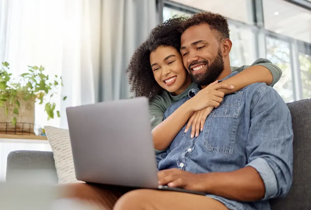 Couple looking at tablet while sitting on couch